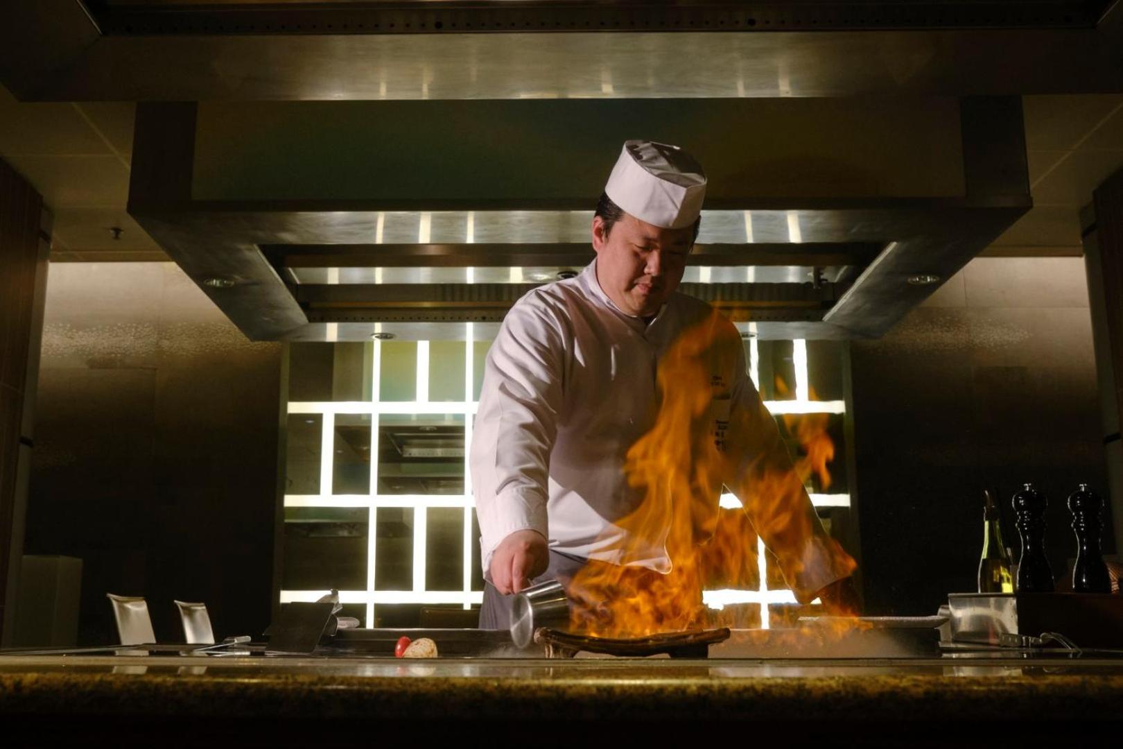 Hotel Okura Amsterdam - The Leading Hotels Of The World Exterior photo A chef cooking with a flaming wok
